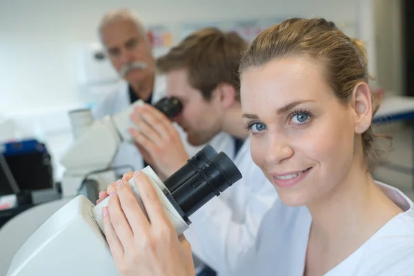 Equipo de científicos en un laboratorio que trabaja con microscopios —  Fotos de Stock