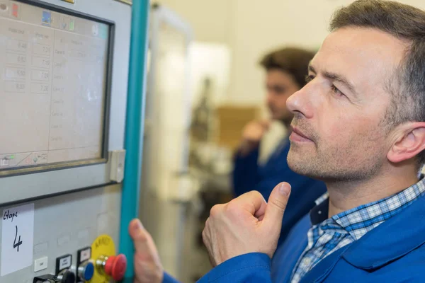 Pekerja pria memeriksa panel kontrol industri canggih — Stok Foto