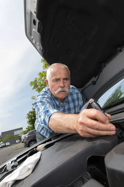 Pensionato manutenzione del suo motore auto — Foto Stock