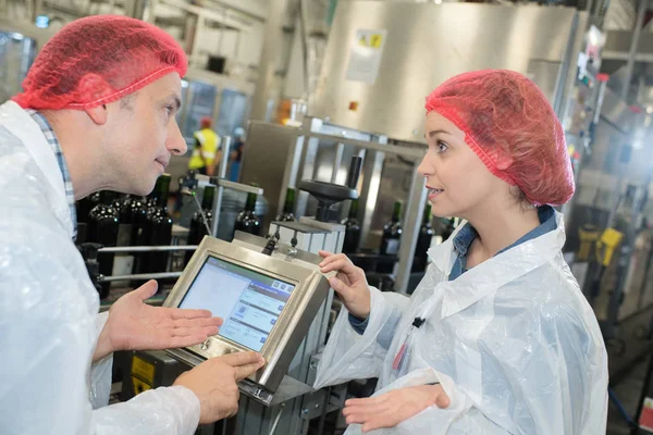 Arbeiter in weißen Gewändern kontrollieren den Gärungsprozess von Wein — Stockfoto