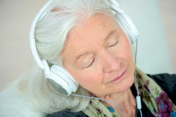 Senior vrouw in hoofdtelefoon — Stockfoto