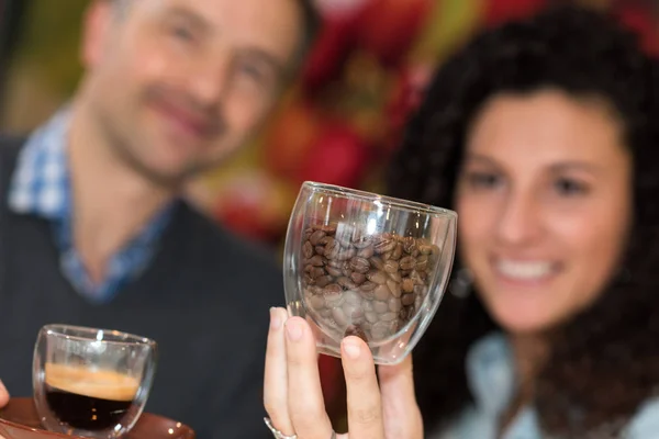 Couple avec café et haricots dans des tasses en verre — Photo