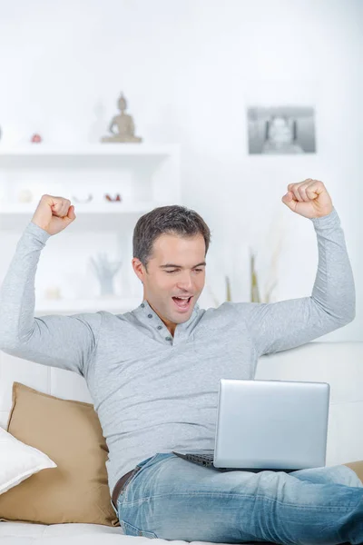 Homem bonito feliz na camisa de manga longa lendo boas notícias — Fotografia de Stock