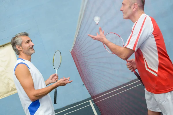 Szczęśliwa para gra badminton wspolnie pomieszczeniu — Zdjęcie stockowe