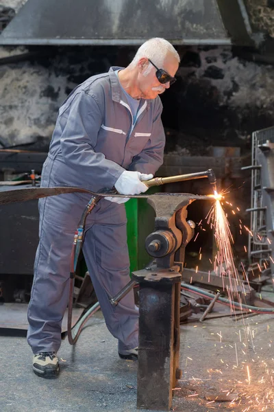 Alter Schweißer, der ein Stahlobjekt bearbeitet — Stockfoto