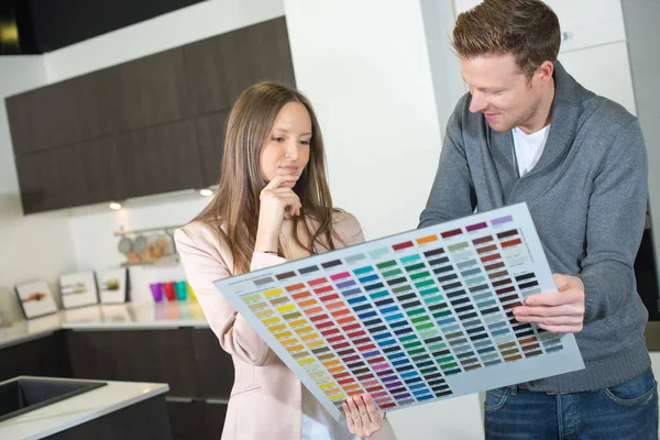 Couple choosing colour of a kitchen — Stock Photo, Image