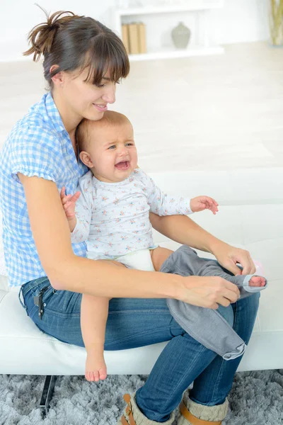 Maman habiller un bébé qui pleure — Photo