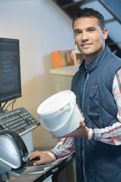 Un assistente negozio di ferramenta seaching per un codice — Foto Stock