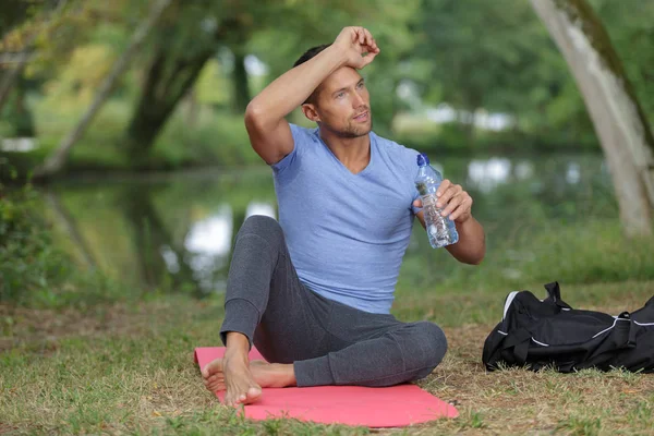 Retrato portsman con botella de agua sentado y relajante al aire libre — Foto de Stock