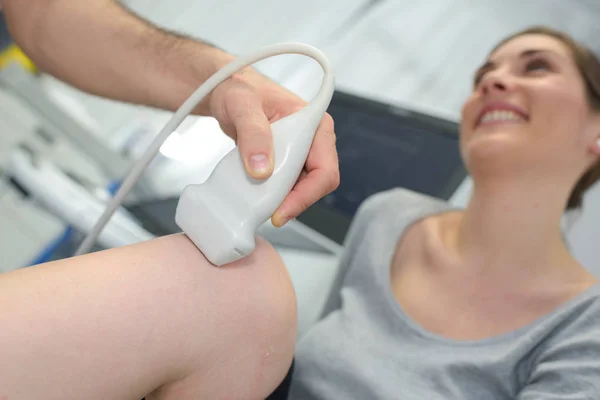 Врач-физиотерапевт проводит лечение на ноге пациента — стоковое фото