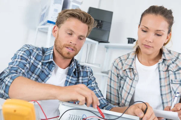 Homem consertar computador com mulher assistindo — Fotografia de Stock