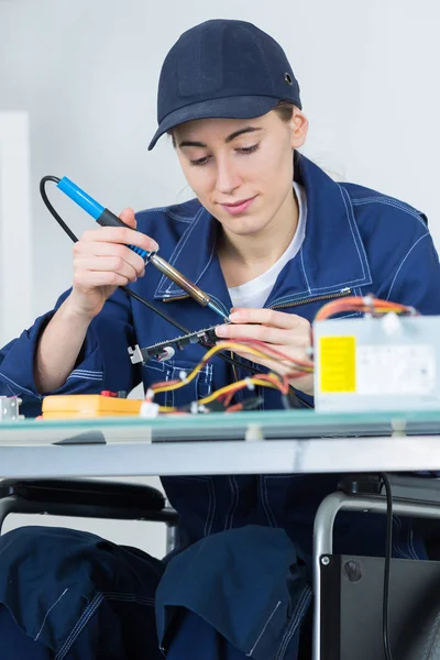 Técnico femenino trabajando en un circuito electrónico — Foto de Stock