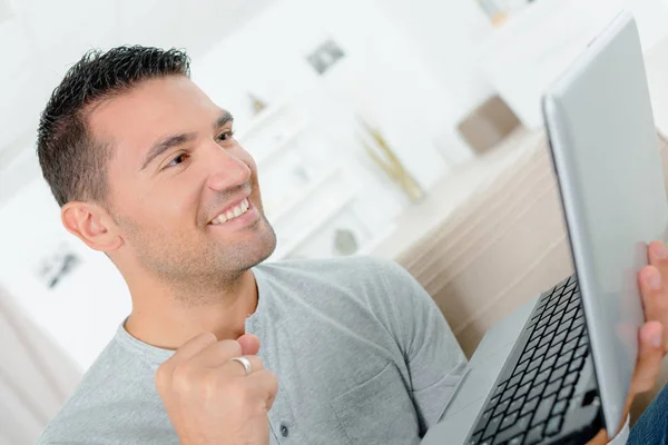 Щасливий чоловік працює з ноутбуком в приміщенні — стокове фото