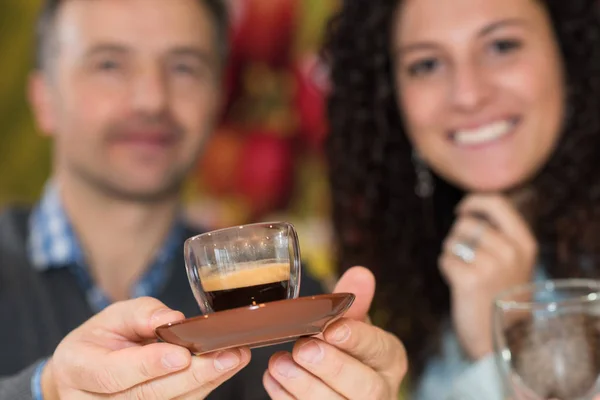 Casal segurando para a frente um expresso — Fotografia de Stock