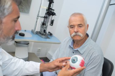 ophthalmologist shows an old patient his view problem clipart