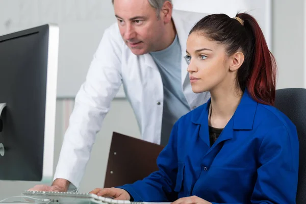 Instructeur helpt een jonge vrouw in een klasse — Stockfoto