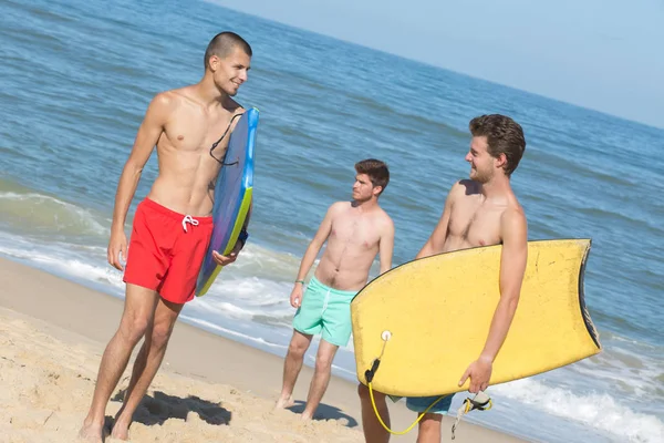 Tři bodyboard surfaři na pláži — Stock fotografie