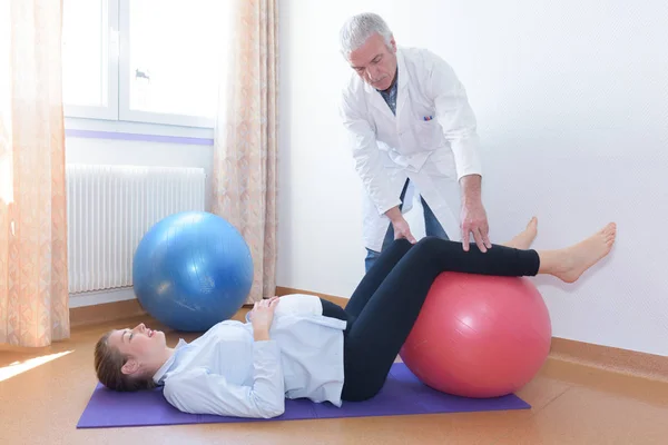 woman doing physiotherapy exercises with fitness ball