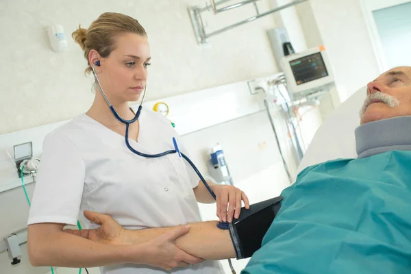 Médico mujer medición de la presión arterial paciente —  Fotos de Stock