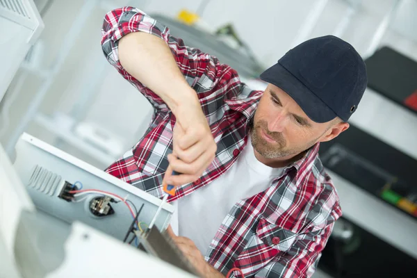 Mann arbeitet an einem Tischrechner in einem Geschäft — Stockfoto