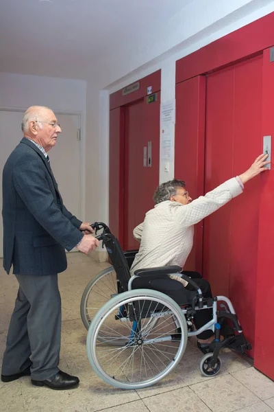 Invalidy zajistit manželka a manžel pomocí výtahu — Stock fotografie