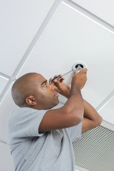 Man fitting spotlight in ceiling — Stock Photo, Image