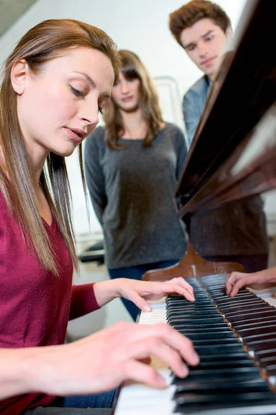 Молодая красивая женщина играет на пианино — стоковое фото