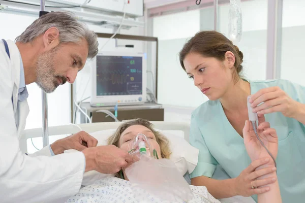 Läkare och sjuksköterska kontroll av en sjuk patient — Stockfoto