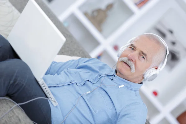 Old-man listening to music from his laptop — Stock Photo, Image