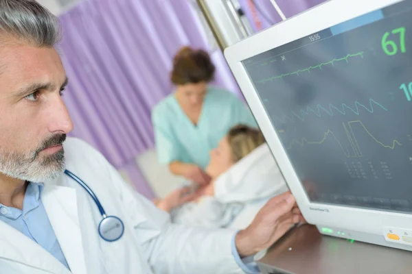 Dokter memeriksa monitor tekanan darah jantung — Stok Foto