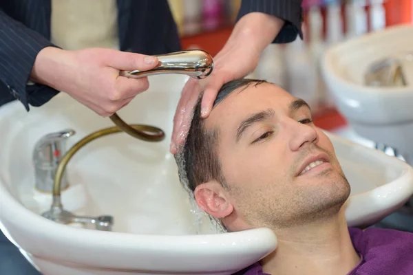 Mann lässt Haare im Friseur waschen — Stockfoto