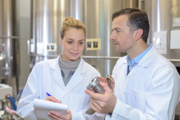 Femme prenant des notes dans une usine — Photo