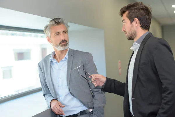 Homem elegante conversando com seu colega de trabalho com a gesticulação — Fotografia de Stock