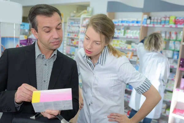 Cliente mostrando prescripción a farmacéutico — Foto de Stock