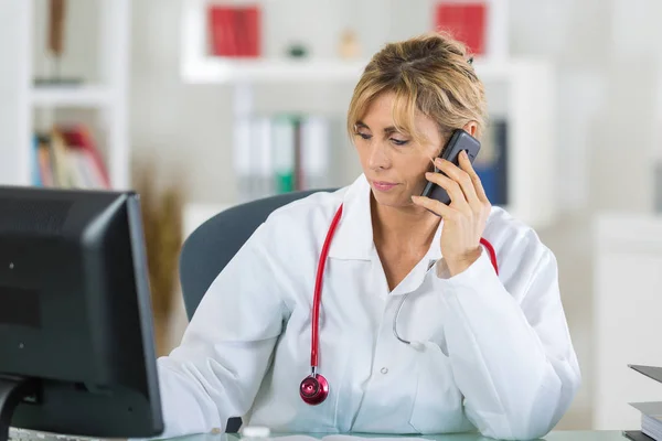 Retrato del médico en el consultorio usando smartphone — Foto de Stock