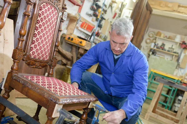 Opravy židlí ve své dílně staré řemeslník — Stock fotografie