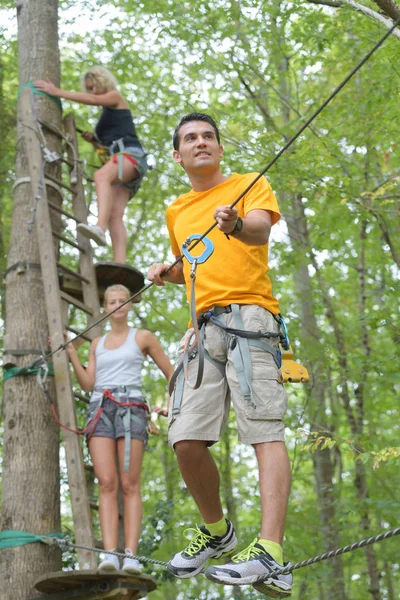 Vrienden plezier klimmen in de bomen — Stockfoto