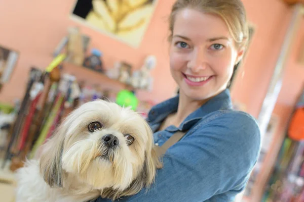 Mulher feliz e cão no salão de aliciamento — Fotografia de Stock