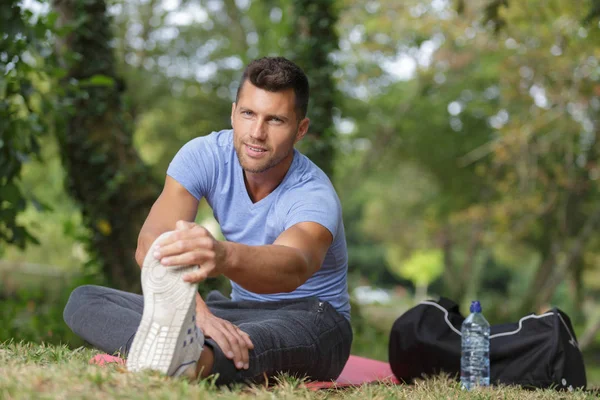 Uomo allungando i muscoli nel parco — Foto Stock