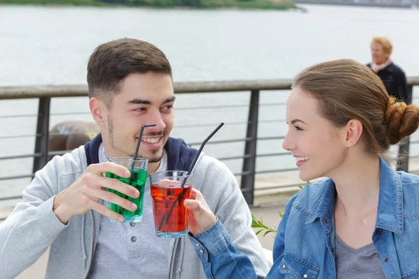 Mladý atraktivní pár opékání s likéry na bar terasa — Stock fotografie