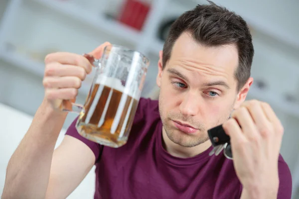 Un homme avec de la bière à la main et des clés de voiture — Photo