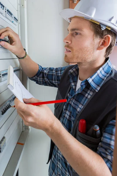 young electrician working on electric panel