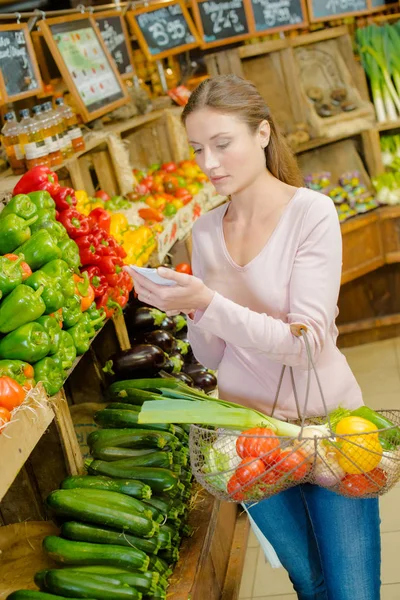 Ung kvinna shopping på grönsakshandlare s — Stockfoto