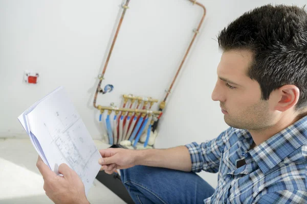 Uomo guardando le istruzioni di cablaggio — Foto Stock