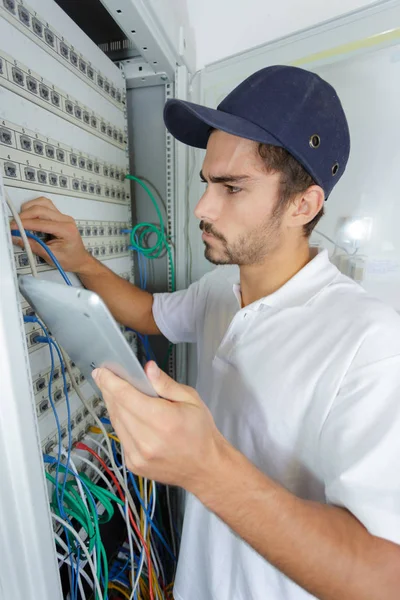 Konzentrierter Elektriker, der Sicherheitsverfahren anwendet, während er an der Schalttafel arbeitet — Stockfoto