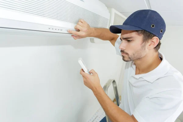 Técnico que comprueba la instalación de CA en el edificio de clientes —  Fotos de Stock