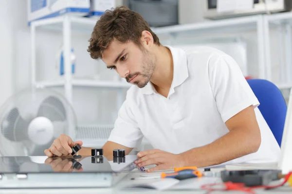 Jovem reparador instalando fogão de indução na cozinha — Fotografia de Stock