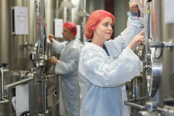 A worker checking a vat for making wine — Stock Photo, Image