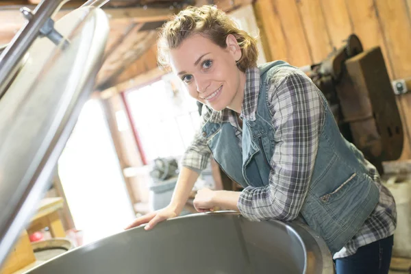 Mulher feliz verificando compartimento de fermentação na fábrica — Fotografia de Stock