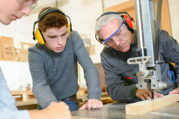 Leraar toont studenten hoe te gebruiken naaimachine — Stockfoto